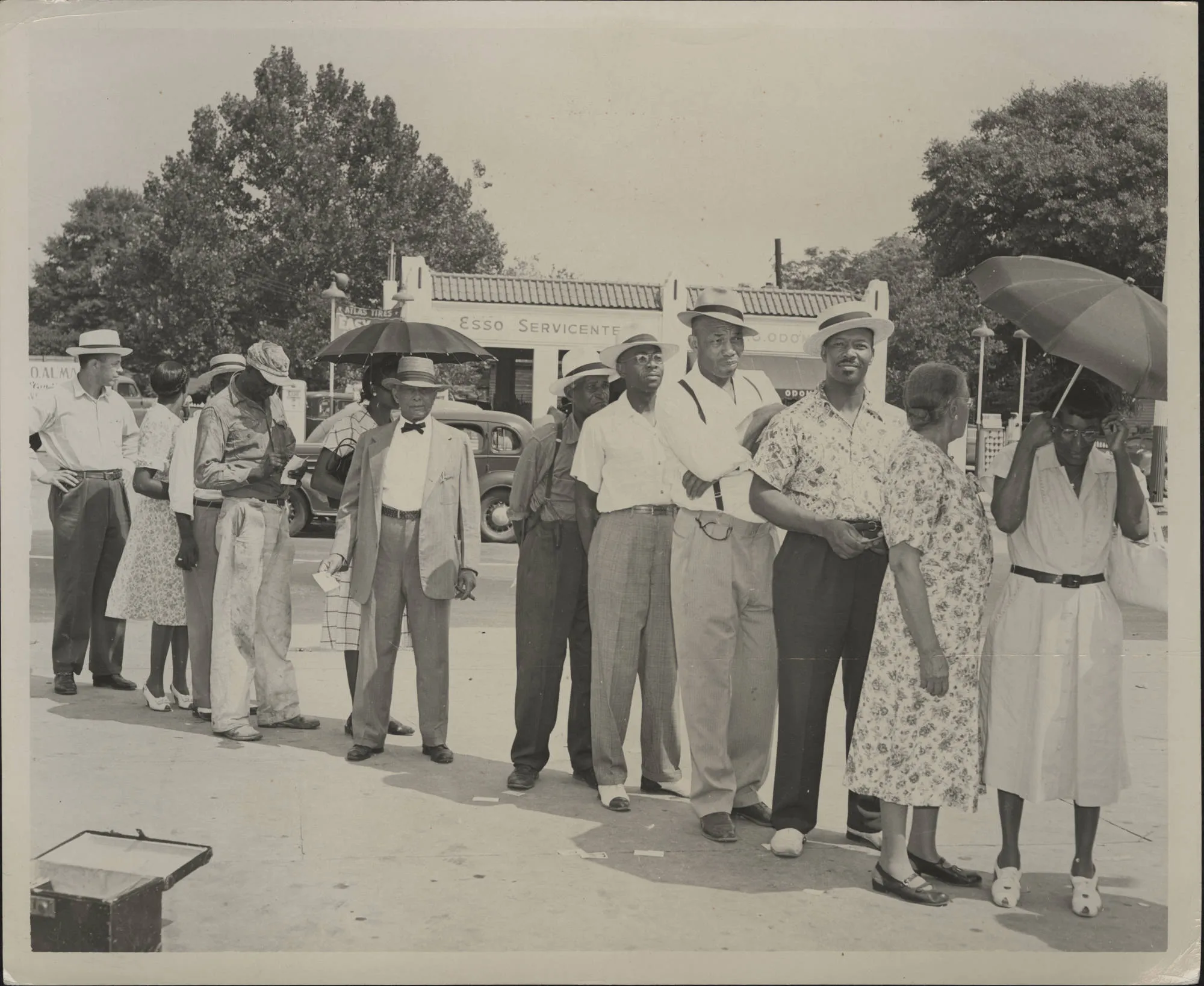 A line of African American men and woman wait to vote.