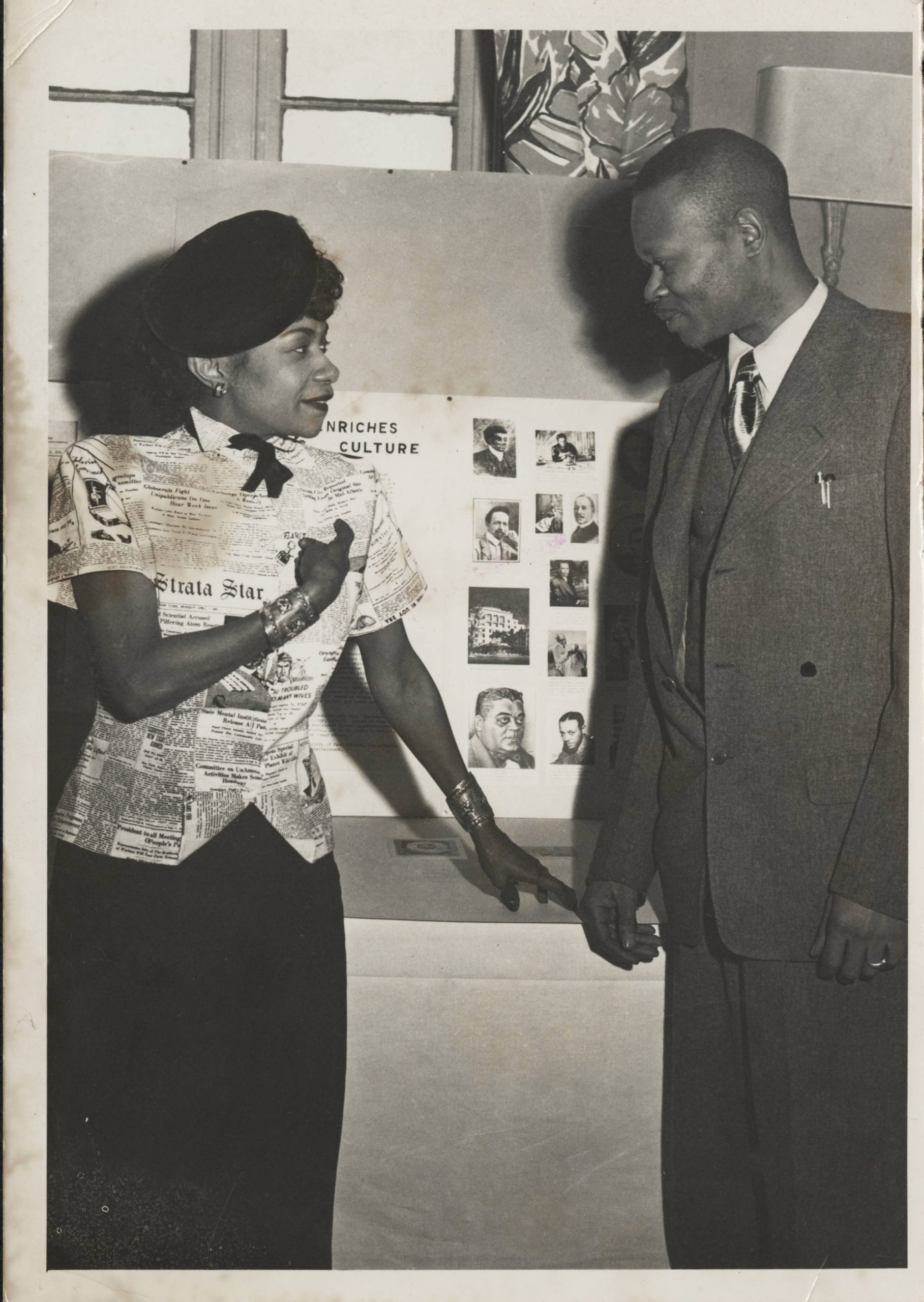 A woman shows a man a Black History Display.